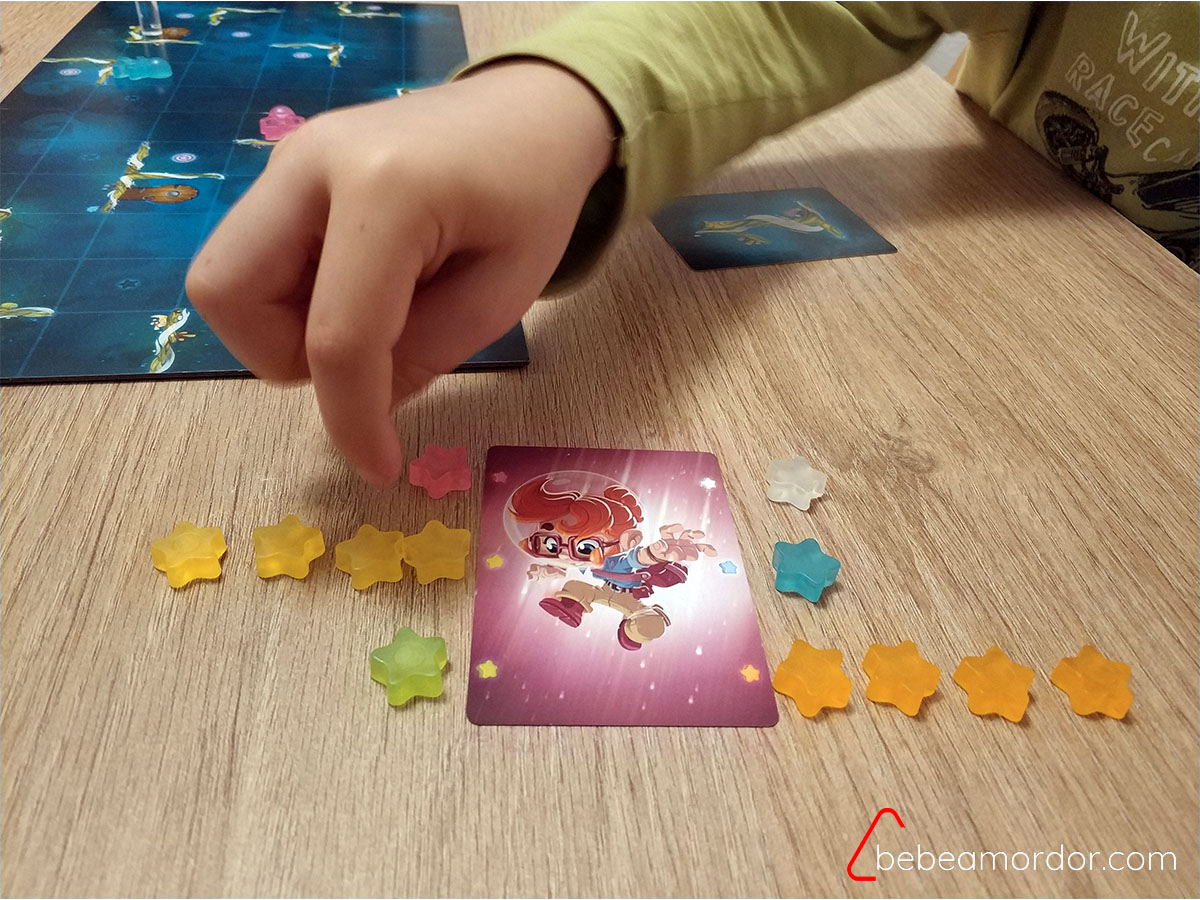 mano de niño contando puntos del juego de mesa Gravity Superstar