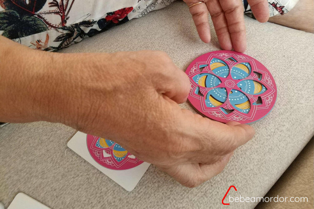 manos de una persona mayor tercera edad jugando al juego de mesa Magic Mandala
