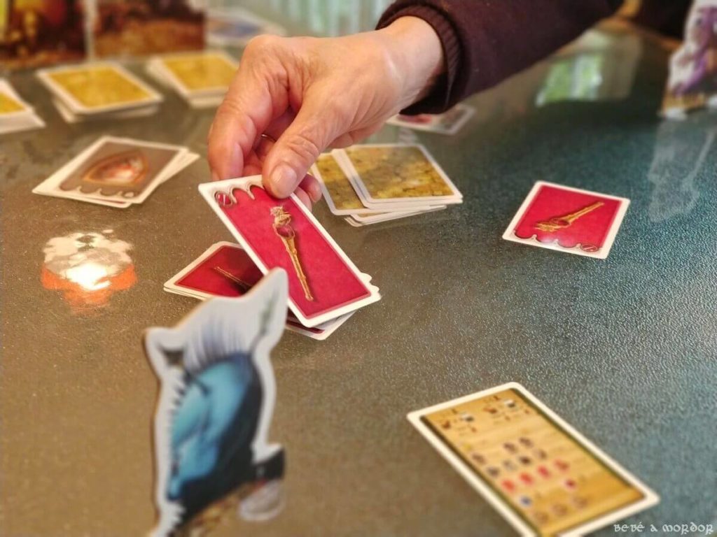 mano de mujer de más de 80 años jugando a juego de mesa Tranjiscolocar carta en montón
