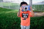 young-diverse-little-boy-taking-a-photograph-with-his-camera_t20_W7WQog