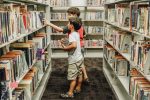 two-children-in-a-library-picking-books-on-the-shelves_t20_mRnQNn