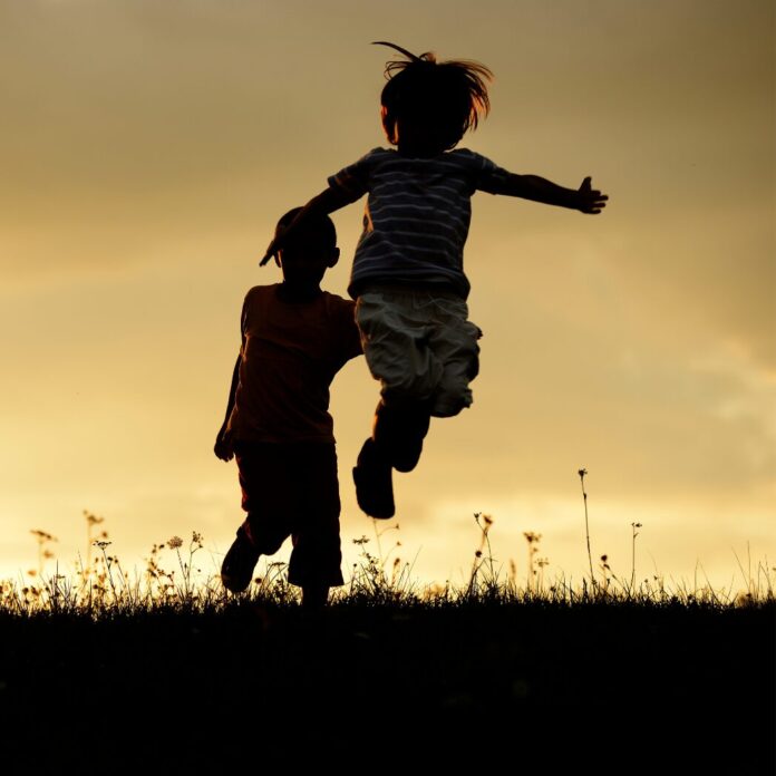 Niños y niñas corriendo por el campo